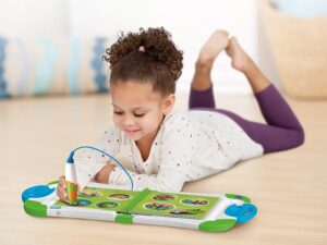Une petite fille qui joue et apprend avec un livre interactif